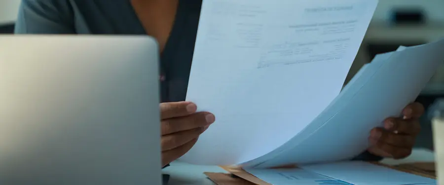Business owner reviewing printed documents at a desk