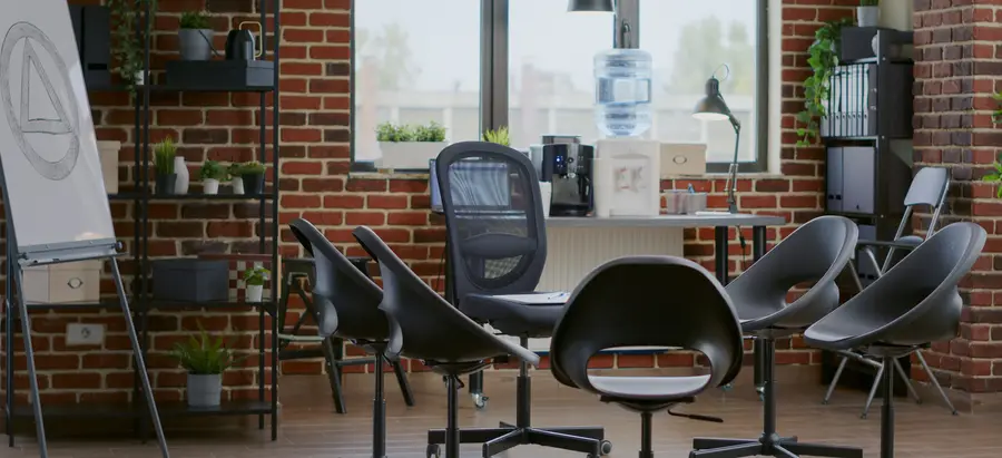 Office meeting area with modern black chairs and exposed brick walls