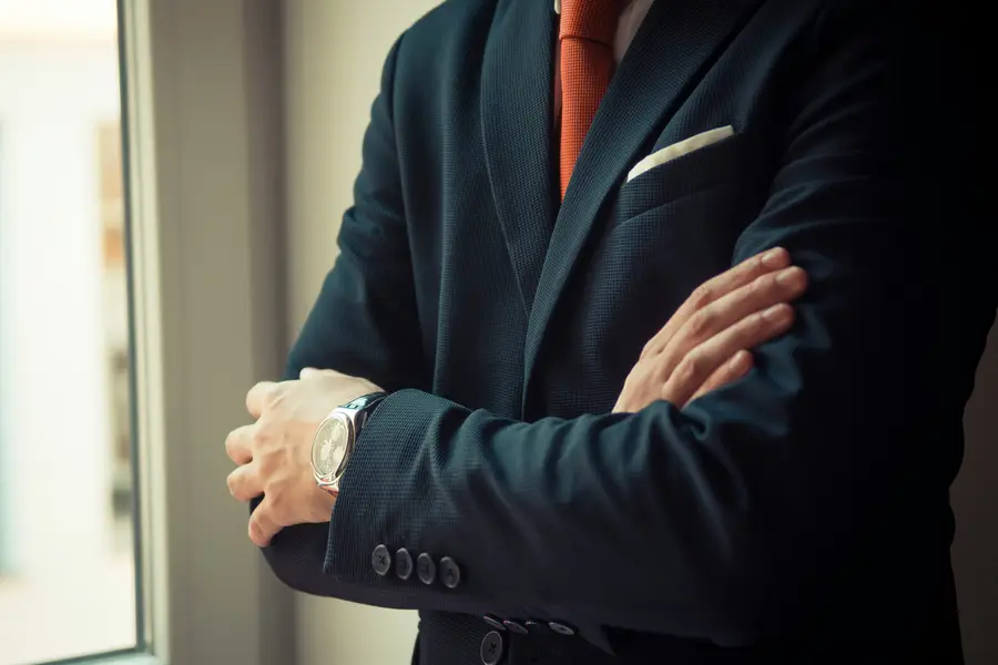 Executive in a dark suit with arms crossed